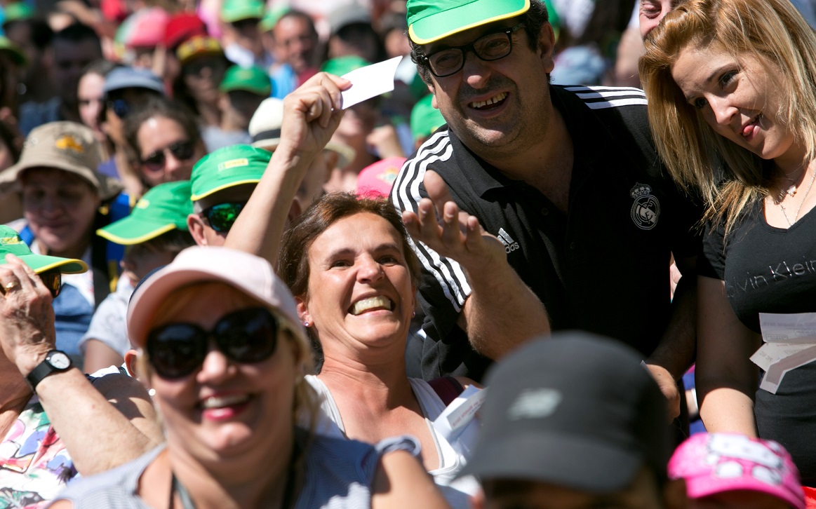 Varios asistentes festejan, en el Parque de Atracciones, un premio del sorteo de regalos celebrado en Madrid