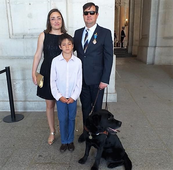 Javier González, junto a su mujer, su hija y su perra guía, a las puertas del Palacio Real