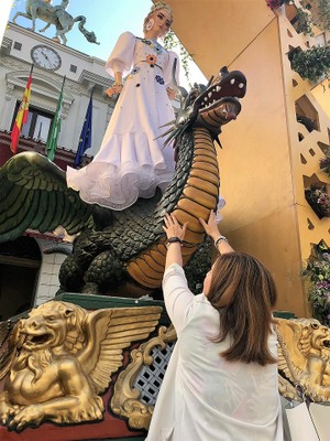 Una afiliada tocando la figura de 'La Tarasca' y el dragón sobre el que va montada