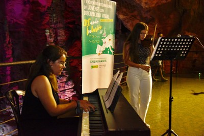 Actuación musical de dos de las participantes en el interior de la cueva