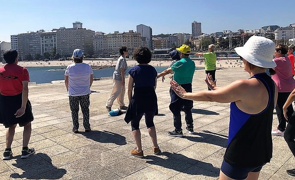 El grupo, practicando Chi-Kung con la playa de Riazor al fondo