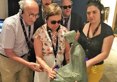 Integrantes del grupo de la ONCE conociendo al tacto una de las esculturas de la muestra