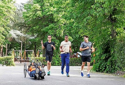 Un grupo de cuatro personas con distintos tipos de discapacidad practican running en un parque