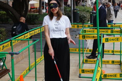 Una joven realiza un circuto de movilidad con antifaz y bastón