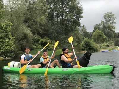 Tres de los jóvenes y uno de los perros guía en una de las canoas
