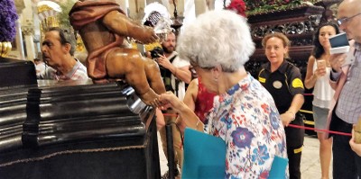 Una afiliada conociendo al tacto uno de los ángeles que custodian el crucificado de San Lorenzo