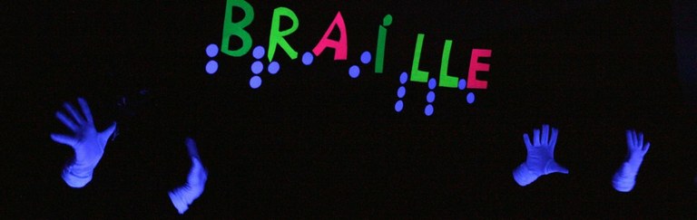 Imagen de manos blancas sobre fondo negro con el rótulo "Braille"