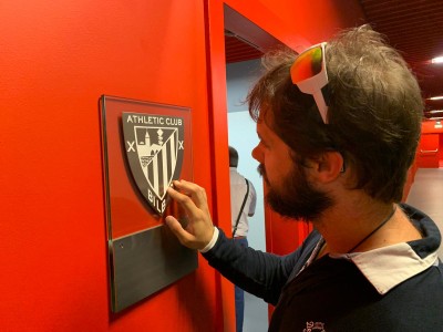 Un afiliado reconociendo al tacto un escudo del Athletic en relieve durante la visita al Museo de San Mamés
