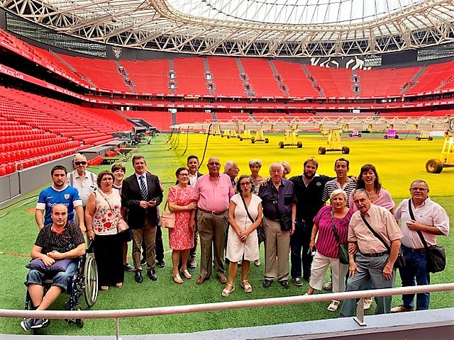Un grupo de afiliados, encabezados por Rafa Ledesma, sobre el césped del estadio del Athletic