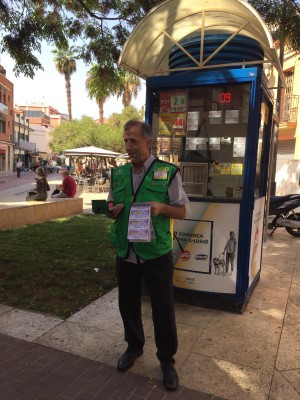 Tomás Pardo García posa delante de su quiosco de venta de los productos de juego de la ONCE