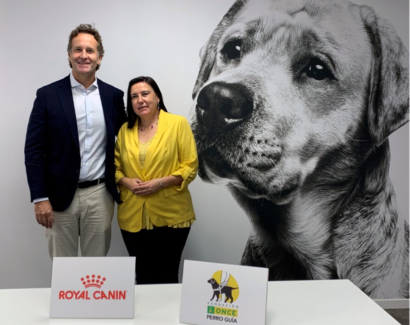 Varela (a la derecha) y Ponçon posan tras la forma junto a un gran póster de uno de los perros guía de la FOPG