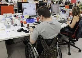 Trabajador con discapacidad en silla de ruedas en su puesto de trabajo