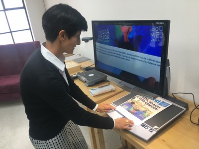 Persona con discapacidad visual consultando un texto impreso a través de una telelupa