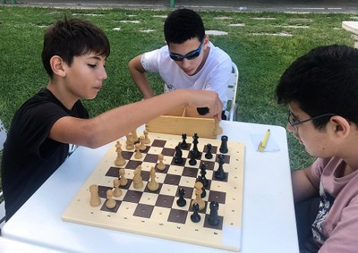 Un alumno come ficha a su contrincante en una partida de ajedrez