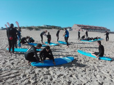 Los participantes con discapacidad visual se familiarizan al tacto con las tablas que habrán de utilizar para surfear