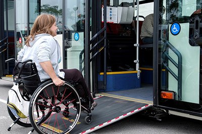 Mujer en silla de ruedas accediendo a un autobús