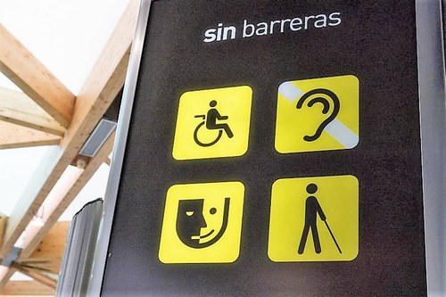 Panel de avisos sobre atención a personas con discapacidad en un espacio público