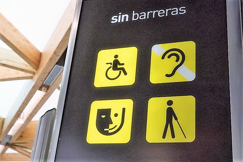 Panel de avisos sobre atención a personas con discapacidad en un espacio público