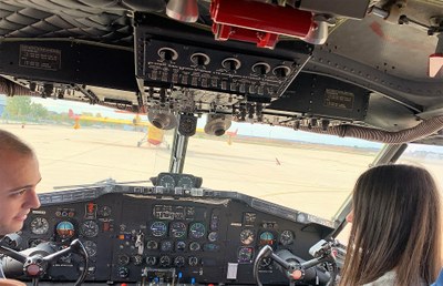 Un piloto explica a una joven afiliada, sentados en la cabina, el funcionamiento de los mandos