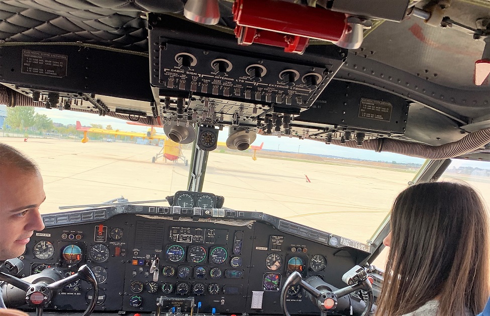 Un piloto explica a una joven afiliada, sentados en la cabina, el funcionamiento de los mandos
