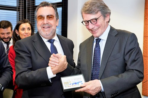 El presidente Carballeda (a la izquierda) hace entrega a David Sassoli de un cupón dedicado al Parlamento Europeo mientras ambos entrelazan sus manos