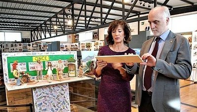 Andueza lee, junto a Teresa Lafragua, una de las cartelas en braille de la muestra, con el belén dedicado a la ONCE al fondo