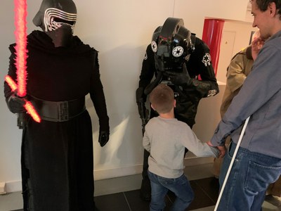 Un niño pequeño, de la mano de su padre, afiliado a la ONCE, se acerca en el Museo Tiflológico a ver de cerca a uno de los soldados del Imperio