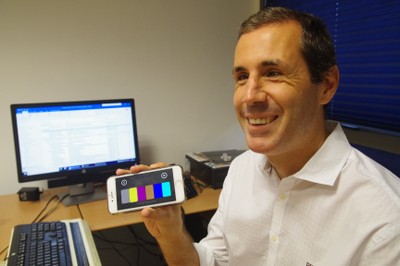 Marcelo Rosado Carrasco muestra sonriente su teléfono con la aplicación para el MasterBrain