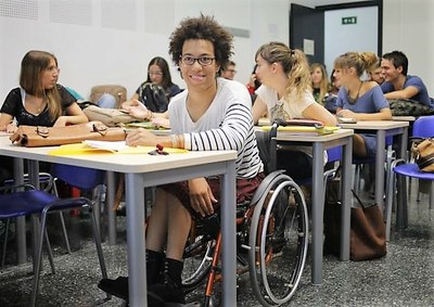 Una joven en silla de ruedas, en el aula, junto al resto de sus compañeros