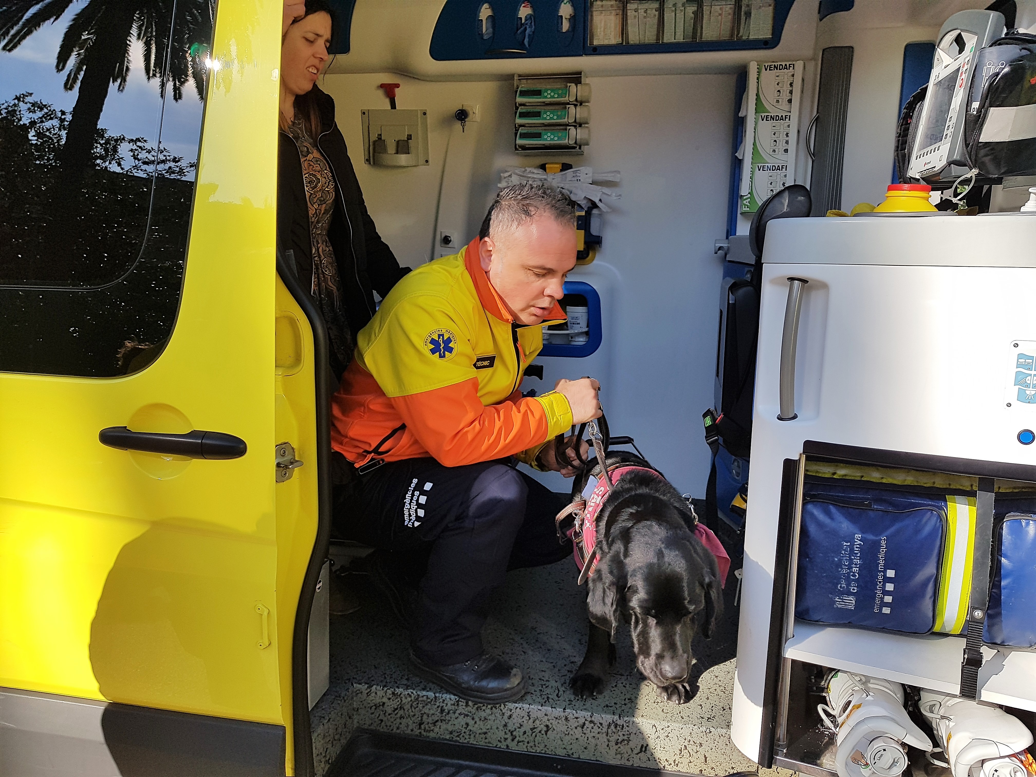 Anaïs, junto a un sanitario y su perra guía 'Cometa', dentro de la ambulancia