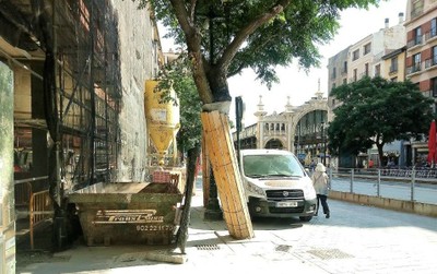 Obras sin señalizar y una furgoneta aparcada sobre la acera en una escena urbana
