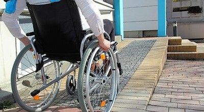 Una persona en silla de ruedas accede por una rampa a un centro sanitario