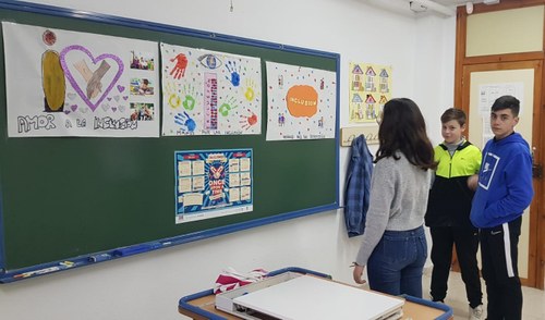 Otro grupo contempla en el tablón del aula algunos de los trabajos