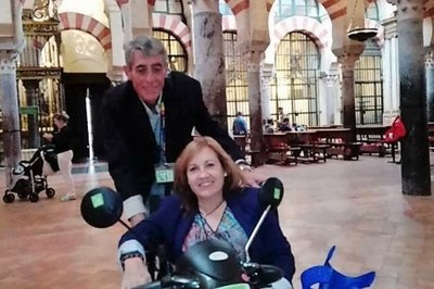 Una persona en silla de ruedas, y su acompañante, durante una visita a la Mezquita