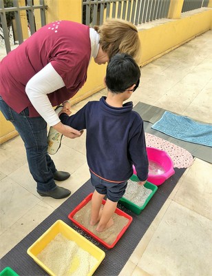 Otro niño recorriendo a ciegas el pasillo de sensibilidad con los pies
