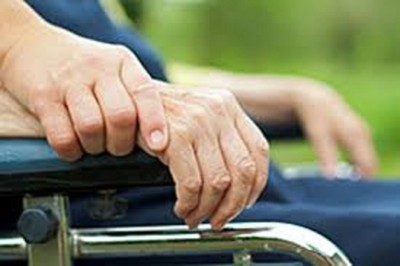Detalle de manos de una voluntaria y de una persona en silla de ruedas