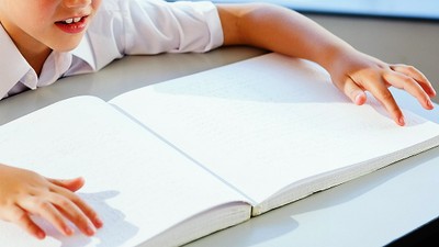 Un niño le en braille