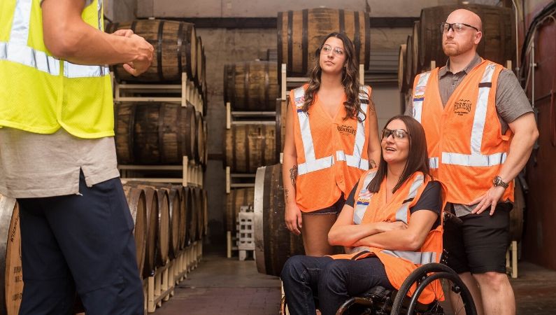 Mujer trabajadora en silla de ruedas junto a sus compañeros de trabajo