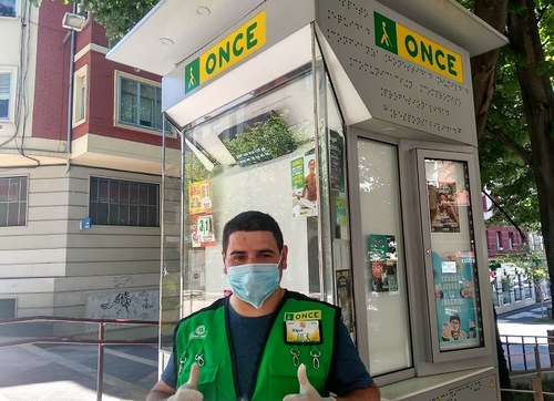 Un vendedor, provisto de mascarilla y guantes, posa junto a su quiosco en Vitoria