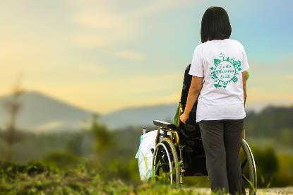 Persona en silla de ruedas con su asistente