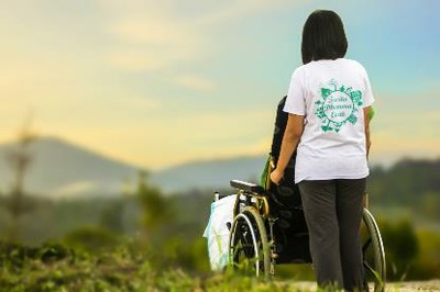 Persona en silla de ruedas con su asistente