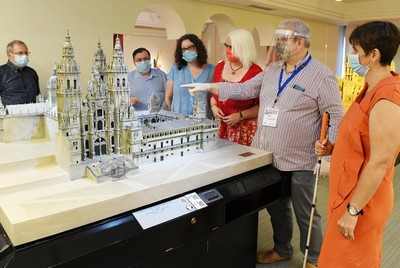 Un grupo de personas durante una visita guiada, junto a un voluntario del museo, ataviado con mascarilla, máscara y guantes Un grupo de personas durante una visita guiada, junto a un voluntario del museo, ataviado con mascarilla, máscara y guantes