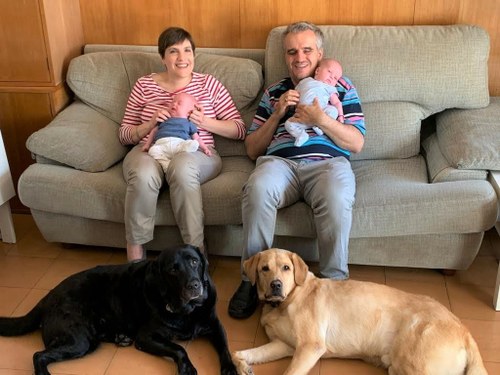 La pareja posa con sus hijos en brazos y sus respectivos perros guía