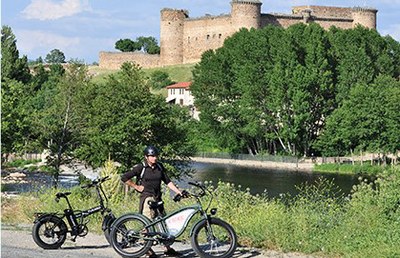 Un turista con bice en el entorno de El Barco con el castillo al fondo