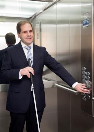 Una persona ciega en un ascensor adaptado