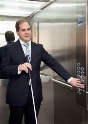 Una persona ciega en un ascensor adaptado