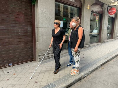 Anabel, guiada por la técnico de la ONCE, se desplaza por la acera de una de las calles colindantes
