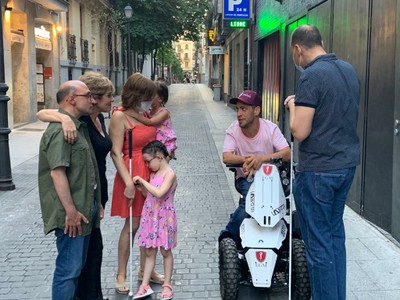 Los actores saludan en la calle a Eugenio y Carolina, una pareja de personas ciegas, junto a sus hijas