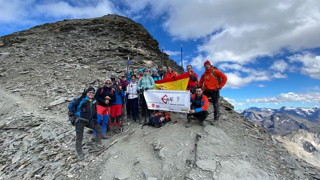Los montañeros posan con la bandera española tras hacer cumbre en el Sassière