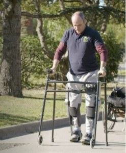 Una persona con movilidad reducida pasea por un parque ayudado por el exoesqueleto creado por la empresa barcelonesa
